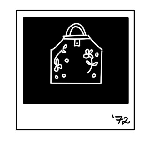 In black and white. An illustrations of a Polaroid of an decorated apron with "'72'" written in the bottom right corner.